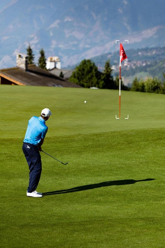 Caddy rangefinder view showing golfer approaching flag
